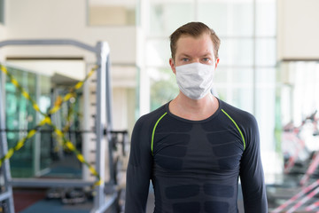 Fototapeta na wymiar Young man with mask for protection from corona virus outbreak at gym during corona virus covid-19