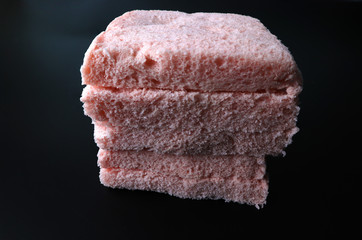 Pink slice of bread on a black background