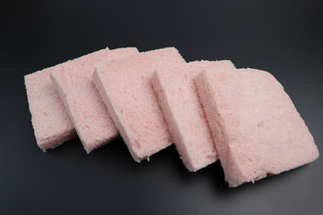 Pink slice of bread on a black background
