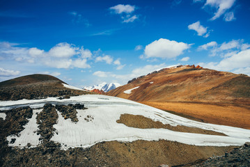 Fototapeta na wymiar Wonderful view to highland valley in golden sunshine among glaciers. Beautiful ice cornice and big snowy mountain. Colorful sunny scenery on high altitude. Awesome alpine landscape with great glacier.