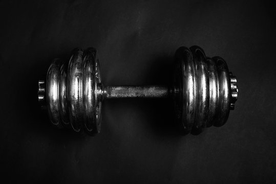 Dramatic black and white photo of dumbbells from above 