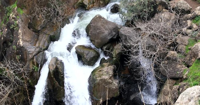 River water flows through the rocks on a cliff.