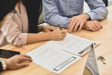 Women sign on document agreement to buying home