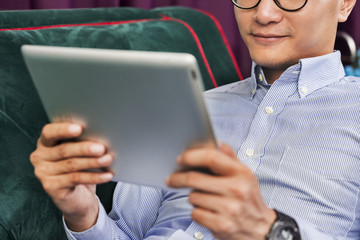 Man using a digital tablet on a couch