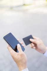Man holding a phone and card