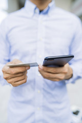 Man holding a phone and card