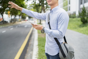 Man holding a mobile phone while hailing for a ride