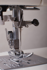 sewing machine with colored thread and needle, on the desktop.