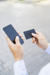 Man holding a phone and card