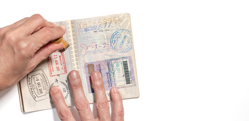Stamping visa on passport pages with a lot of visa stamps.