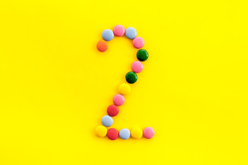 Candies font. Number 2 - two - on yellow background top view