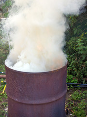 Fototapeta na wymiar An old barrel is used as a waste incinerator