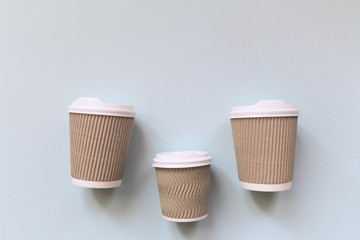 Paper cups of coffee to go on pastel background.