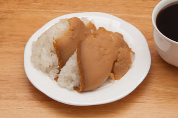 Black coffee and sticky rice with custard on a wooden table