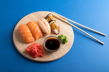 Delicious appetizing nigiri sushi set served on wooden plates with soy sauce and chopsticks. Flat...