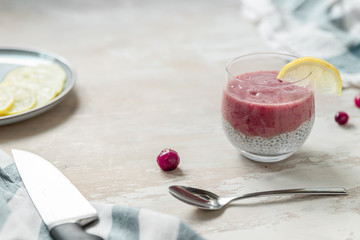 Superfood chia seed pudding in oat milk with mashed berry and lemon. Copy space dessert on a beige table