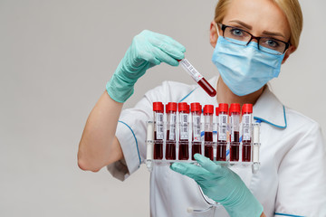 medical doctor nurse woman wearing protective mask and gloves - holding rack with virus blood tests