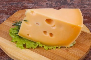 Maasdam cheese  in the board served salad leaves