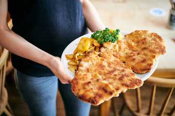 Wiener Schnitzel mit Pommes Frites und Bratkartoffel im Restaurant zum essen