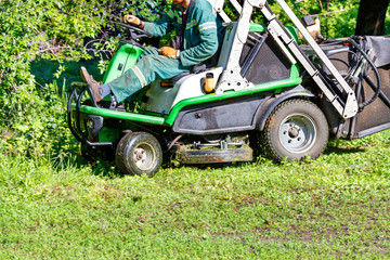 An off-road tractor mower is a necessary garden tool for maintaining park lawns near large shrubs...