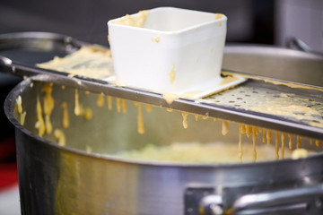 Spätzle Knöpfle Käsespätzle selber machen Teig durch Sieb Pressen in Kochtopf
