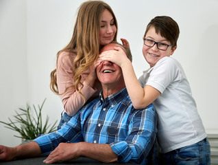 Grandchildren love their grandpa, grandchildren romp with their grandpa and have fun