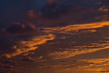 Dramatic blue and yellow evening sky with clouds and some sunlight