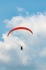 Manned paraglider flying in the blue sky