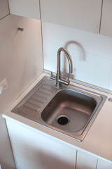 Sink on the kitchen. Close-up. Modern interior. White wall. 