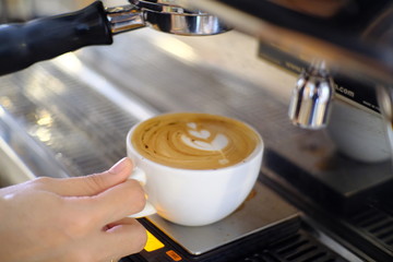Fototapeta na wymiar Barista making a cup of coffee latte art.
