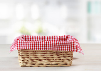 Empty straw basket with red checkered picnic cloth empty space food advertisement design.