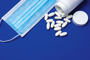 Vitamins and face protective mask close up. Coronavirus prevention concept