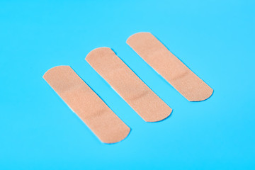 Row of sticky medical patches on blue background. Healthcare concept