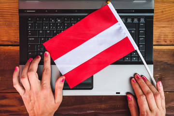 woman hands and  flag of Austria on computer, laptop keyboard
