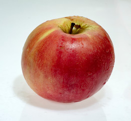 ripe juicy apple with drops of water after washing isolated on white background