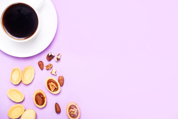 Homemade Russian nuts with condensed milk on a light pink background, wafer napkin. Cut nuts with condensed milk. Bitten goodies for coffee.