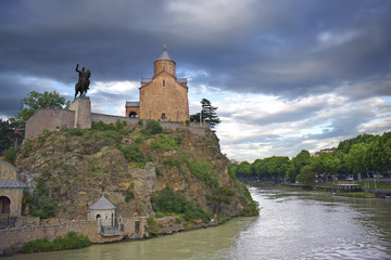 church with a monument  on the rock of the river in old tbilisi