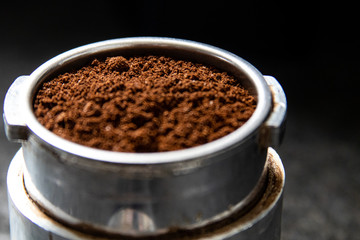 Filter holder for espresso coffee machine with coffee powder in detail. Italian espresso and fresh grinded coffee beans