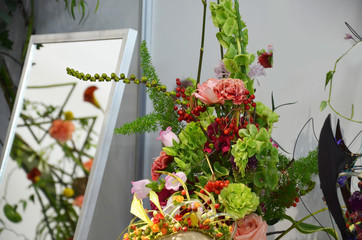 Floral shop concept . Florist creates flower in a wicker basket. Beautiful bouquet mixed flowers. fresh bunch. Flowers delivery. Colorful bouquet of different orchids, roses, freesia eucalyptus leaves