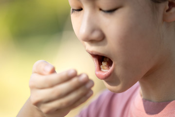 Child girl checking breath with her hand,woman doing a bad breath test after have breakfast,foul mouth from inside the tongue,teeth and gums,oral bacteria problems,halitosis,health care,dental concept