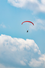 Manned paraglider flying in the blue sky