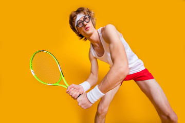 Portrait of his he nice funky successful focused motivated foxy guy playing tennis serving spending vacation free spare time isolated over bright vivid shine vibrant yellow color background