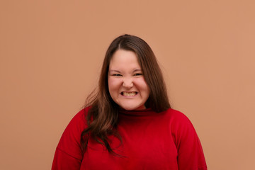 Fototapeta premium The evil girl looks into the camera. An overweight girl.