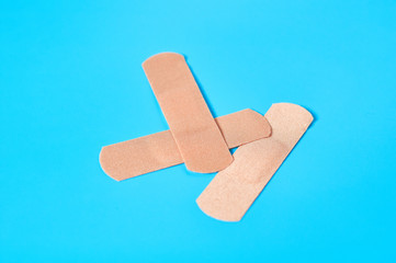 Heap of sticky medical patches on blue background. Healthcare concept