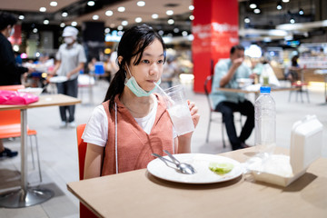 Social distancing,asian child girl is eating at a food court,new normal life after Coronavirus quarantine or Covid-19,people to sit and eat by separating the tables,keeping distance,safety,health care