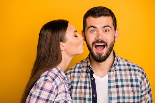 Closeup photo amazed guy couple stand close together open mouth pretty lady kissing his cheekbone crazy facial expression wear casual plaid shirts outfit isolated yellow color background