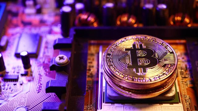 Golden coins with bitcoin symbol on a main board computer.	