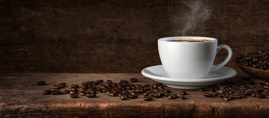Cup of coffee and coffee beans on wooden table