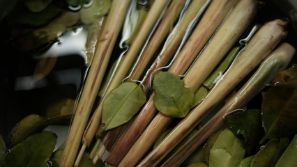 Lemongrass and kaffir lime leaves soak in water before cooking.