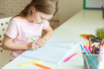 Cute little child girl drawing at home